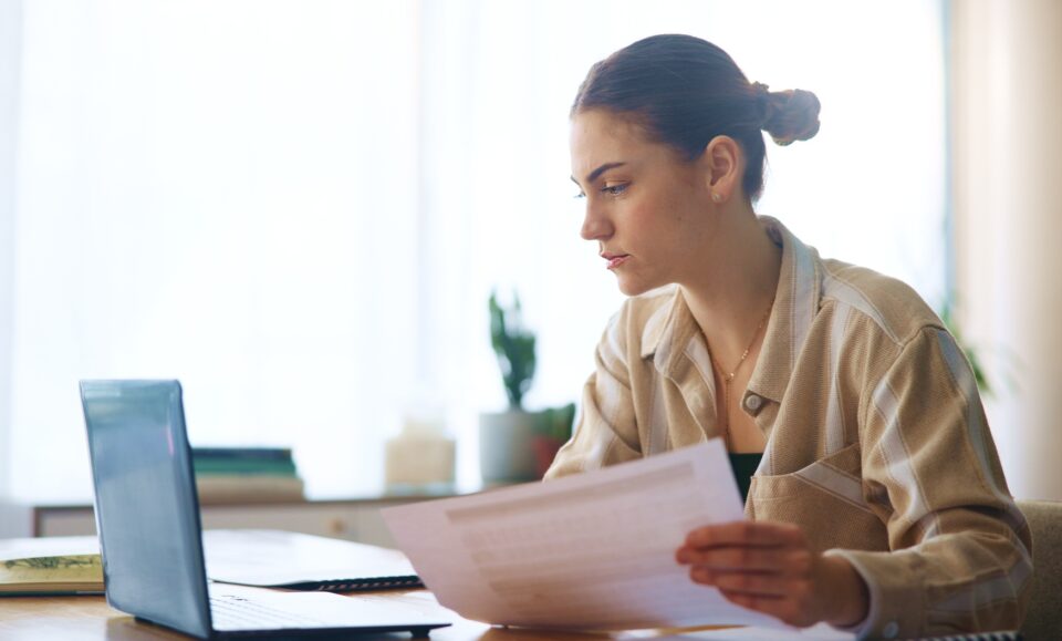 Girl, reading and laptop with document at house for loan approval, bank application and budget plan